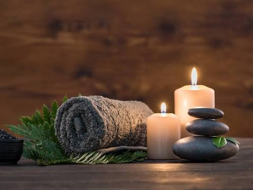 Rolled towel with candles and smooth stones