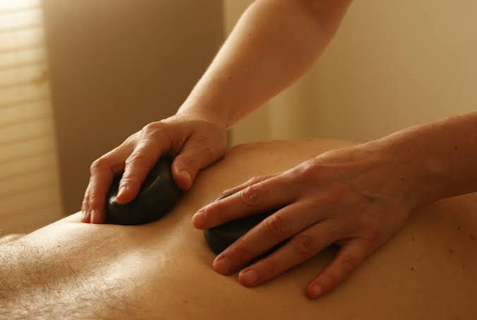 Hot stone massage being performed on a guest's back